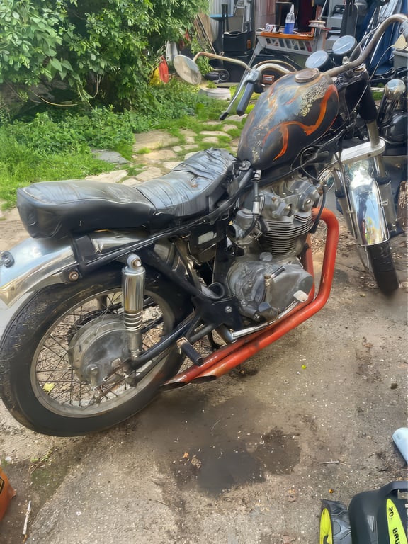 1974 Honda CB450 K4 “Krusty”: full side view in the shop, with orange exhaust headers