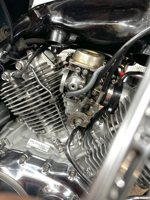 1995 Yamaha Virago 1100 on the lift: carburetor and its hoses between the V-twin cylinders